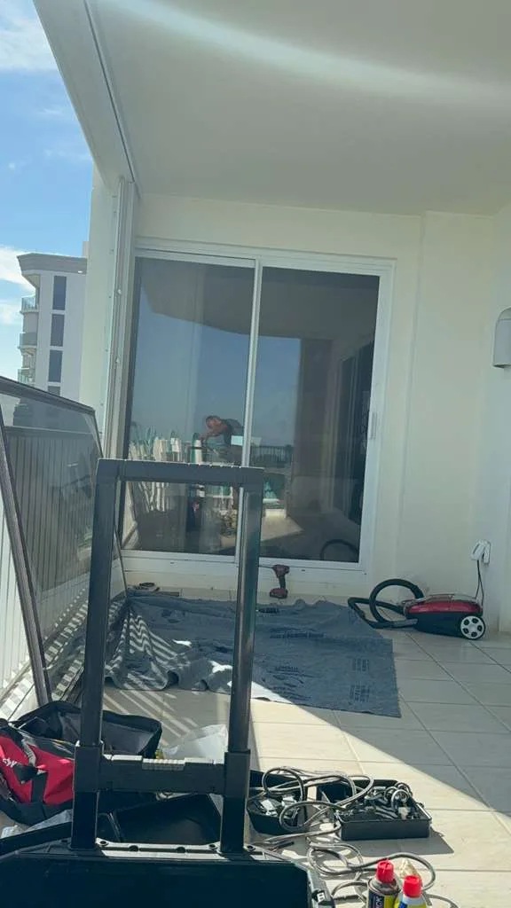 Technician repairing a sliding glass door at a Fort Pierce home