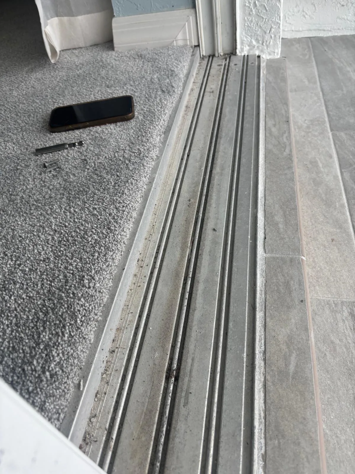 Treasure Coast Sliding Door Repair technician fixing a track with pool in background