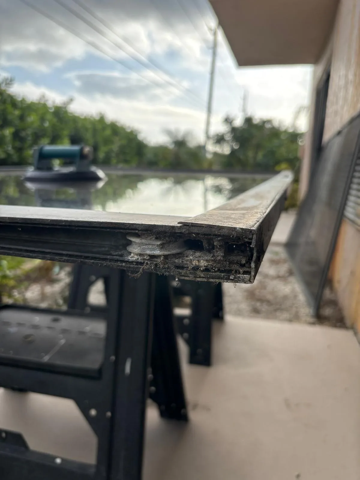 Worn sliding door rollers showing damage from coastal conditions